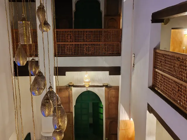 Inner courtyard with a green door, gallery and carved wood
