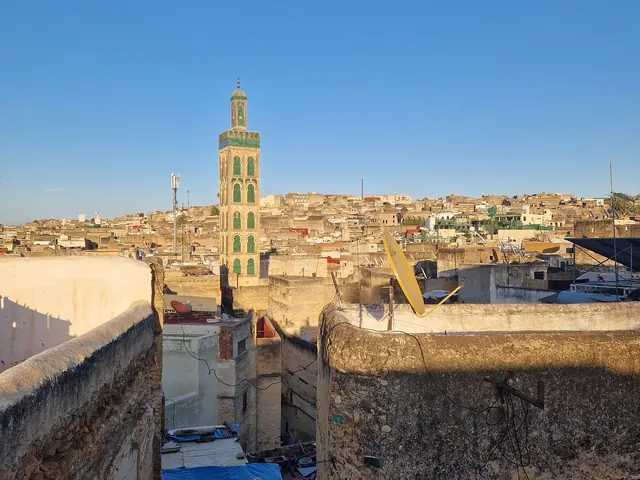 Rooftop view across the Fès Medina toward a minaret
