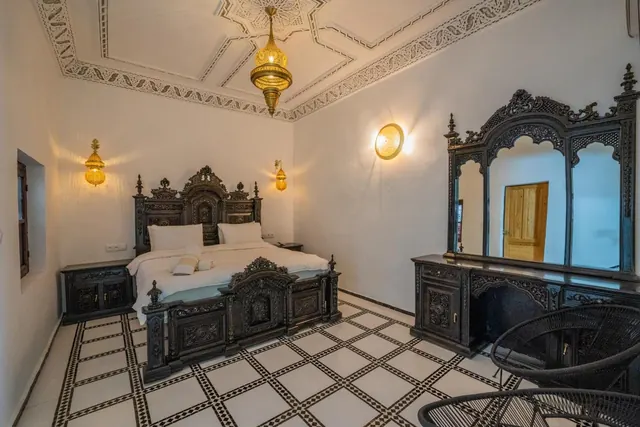 Guest bedroom with carved wood and a black-and-white tiled floor